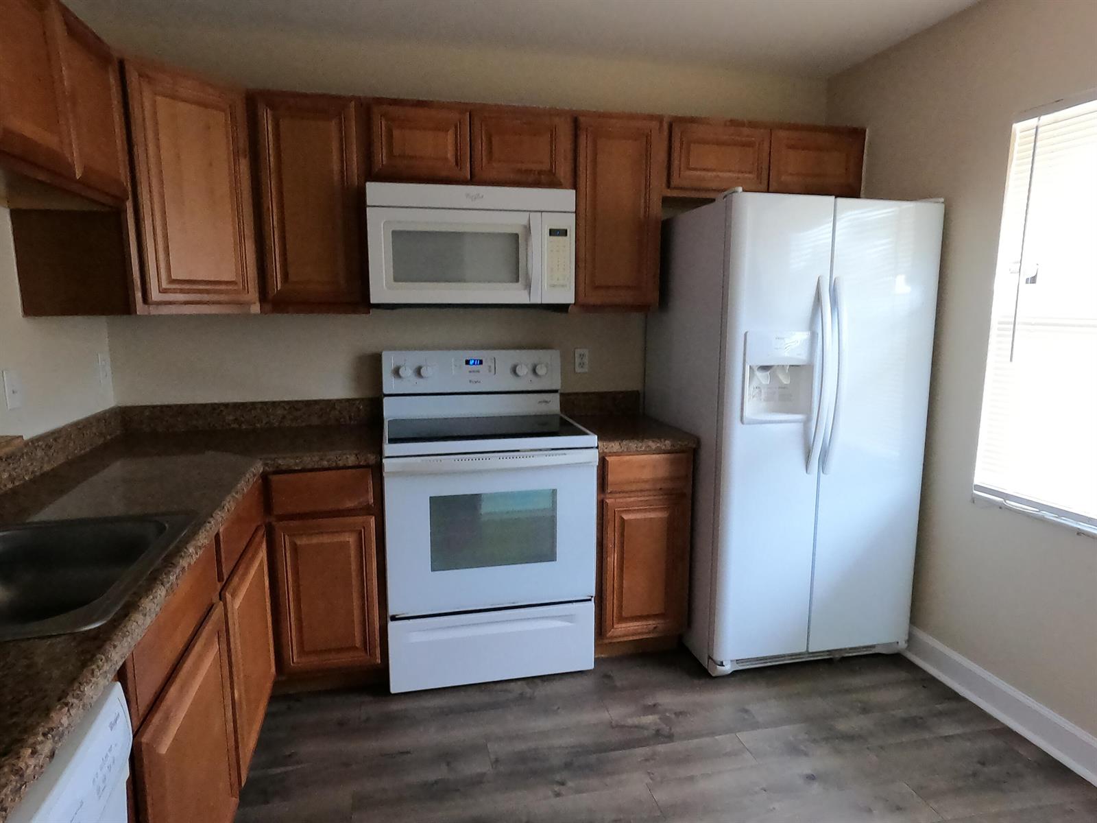 A kitchen features wood cabinets, white appliances, brown countertops, and wood-look flooring — 16363 Water Way, Delray Beach FL 33484, DELRAY BEACH, FL