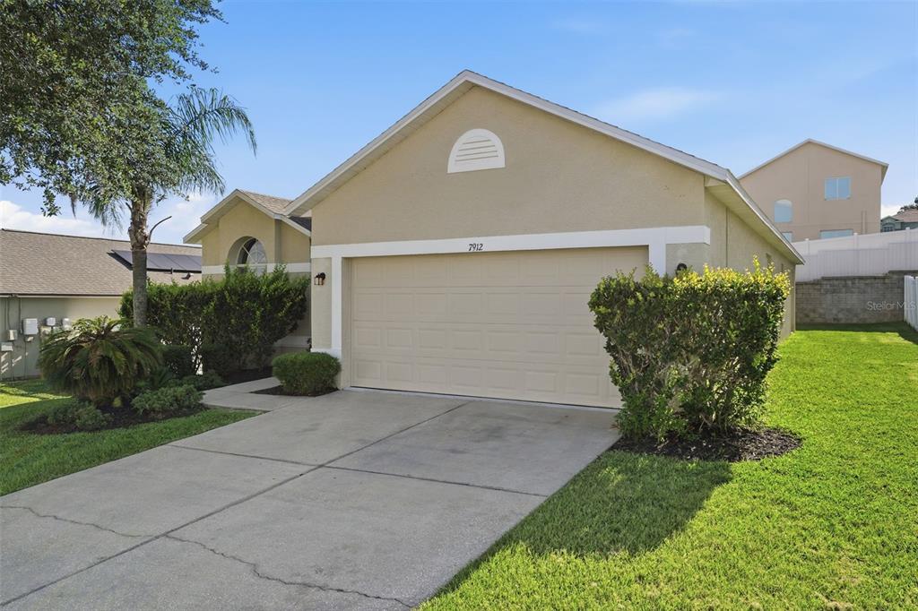 A dining room with a wooden table, chairs, and a sideboard, featuring a vaulted ceiling — 7912 MERCHANTVILLE CIRCLE, ZEPHYRHILLS, FL