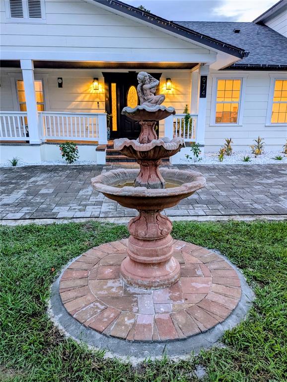 A white house with a black front door, a covered porch, and brick steps — 974 PINELLI STREET, ORLANDO, FL
