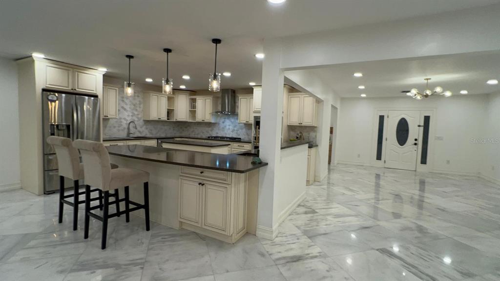 A dining room features a wooden table with six chairs, a chandelier, and marble flooring — 974 PINELLI STREET, ORLANDO, FL