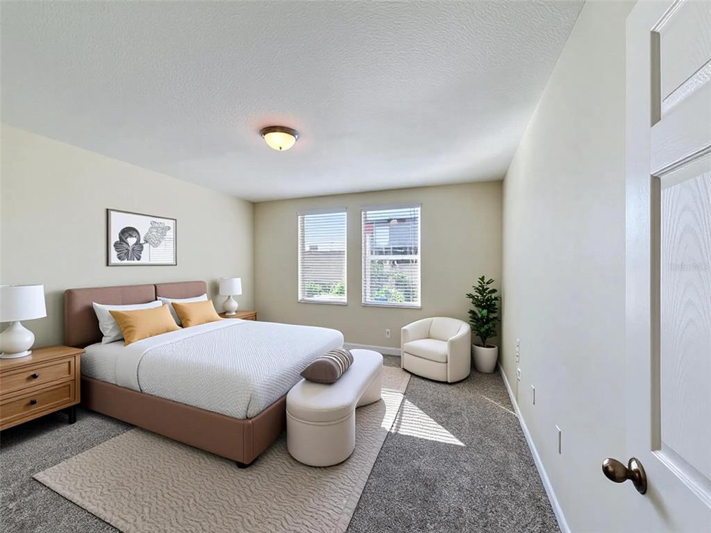 A bedroom features a bed with a tan headboard, two windows, and a white armchair — 520 KENNEDY DRIVE, LAKE ALFRED, FL