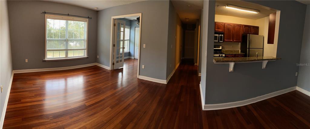 An open-concept living area features hardwood floors, a window, and a kitchen with a breakfast bar — 2047 DIXIE BELLE DRIVE UNIT 2047H, ORLANDO, FL