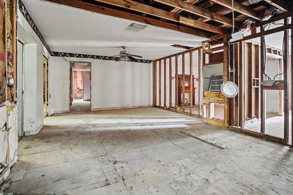 An interior view of a room under renovation with exposed wall studs and plywood subflooring — 4921 DEESON ROAD, LAKELAND, FL