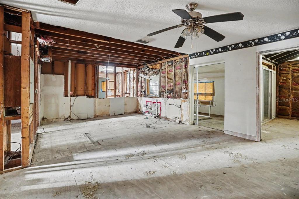 An interior room under renovation with exposed wall studs, insulation, and a ceiling fan — 4921 DEESON ROAD, LAKELAND, FL