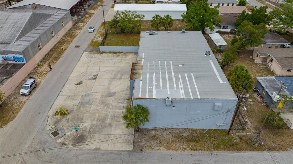 An aerial view shows a gray commercial building with a large adjacent concrete parking lot — 1001 E SKAGWAY AVENUE, TAMPA, FL