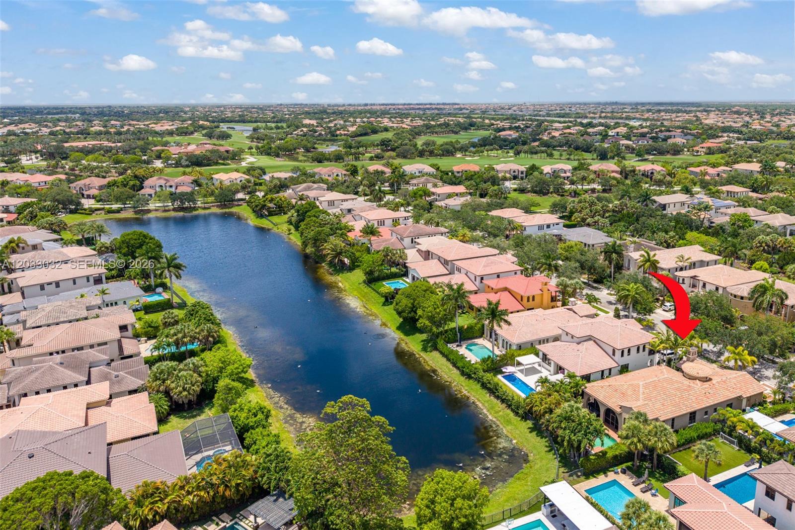 An aerial view shows a residential neighborhood with houses, swimming pools, and a central lake — 9534 Ginger Ct, Parkland FL 33076, PARKLAND, FL