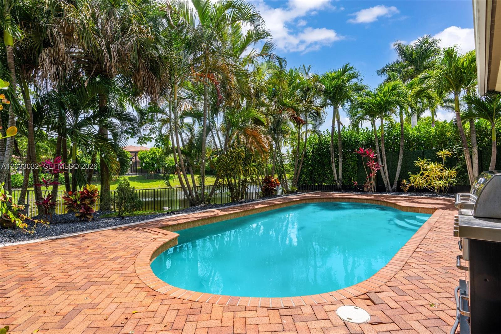 A single-story house with a two-car garage, arched entryway, and a brick-paved driveway — 9534 Ginger Ct, Parkland FL 33076, PARKLAND, FL