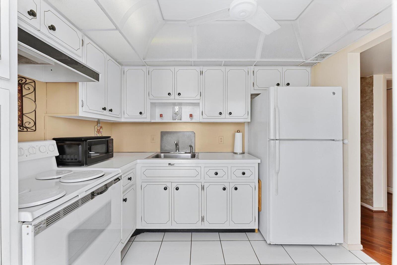 A kitchen with white cabinets, white appliances, a tiled floor, and a drop ceiling — 201 N Ocean Boulevard # 1102, Pompano Beach FL 33062, POMPANO BEACH, FL