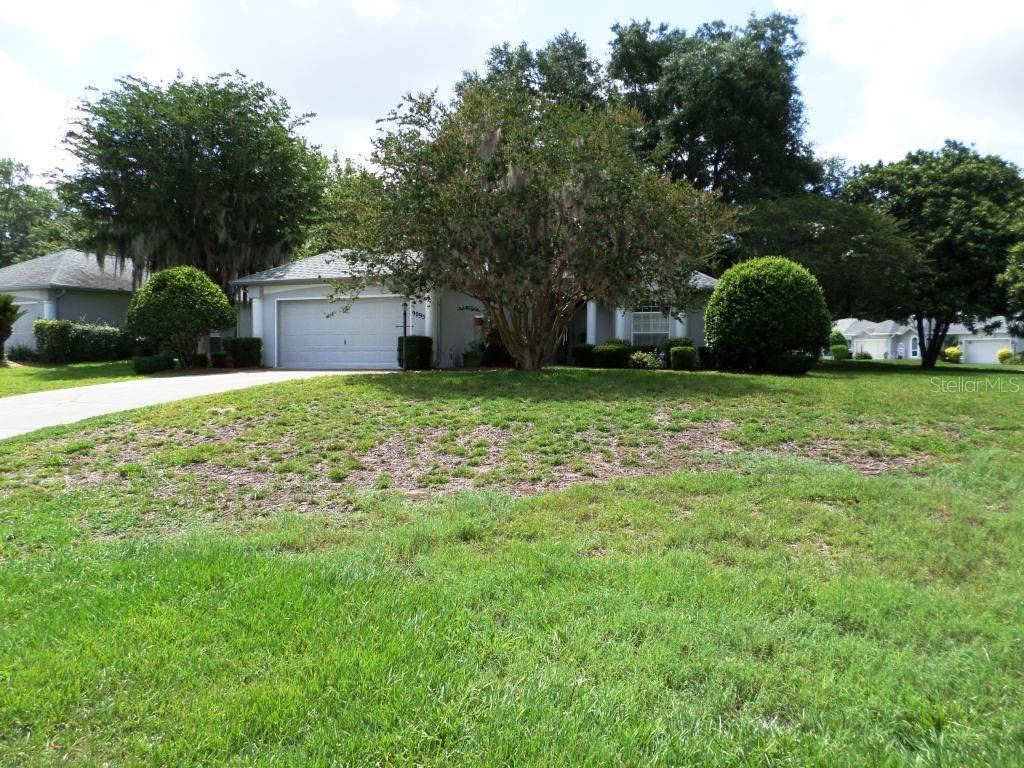 A single-story house with a two-car garage and a large tree in the front yard — 9093 SW 192ND COURT RD, DUNNELLON, FL