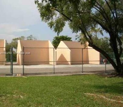 A fenced outdoor handball court with two concrete walls stands on a grassy lot — 8760 SW 133rd Ave Rd # 318, Miami FL 33183, MIAMI, FL