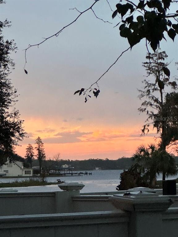 A white picket fence overlooks a pond with a small boat and apartment buildings beyond — 13709 JUNIPER BLOSSOM DRIVE UNIT 0, TAMPA, FL
