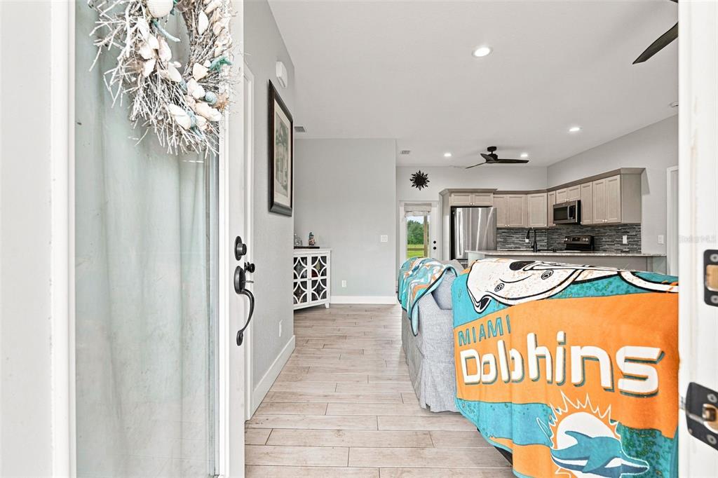 An interior view from a doorway shows a living area with a Miami Dolphins blanket — 4651 SW PROVAU AVENUE, ARCADIA, FL