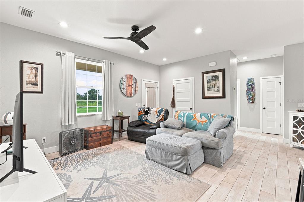 A living room features light tile flooring, a ceiling fan, a sofa, and a window — 4651 SW PROVAU AVENUE, ARCADIA, FL