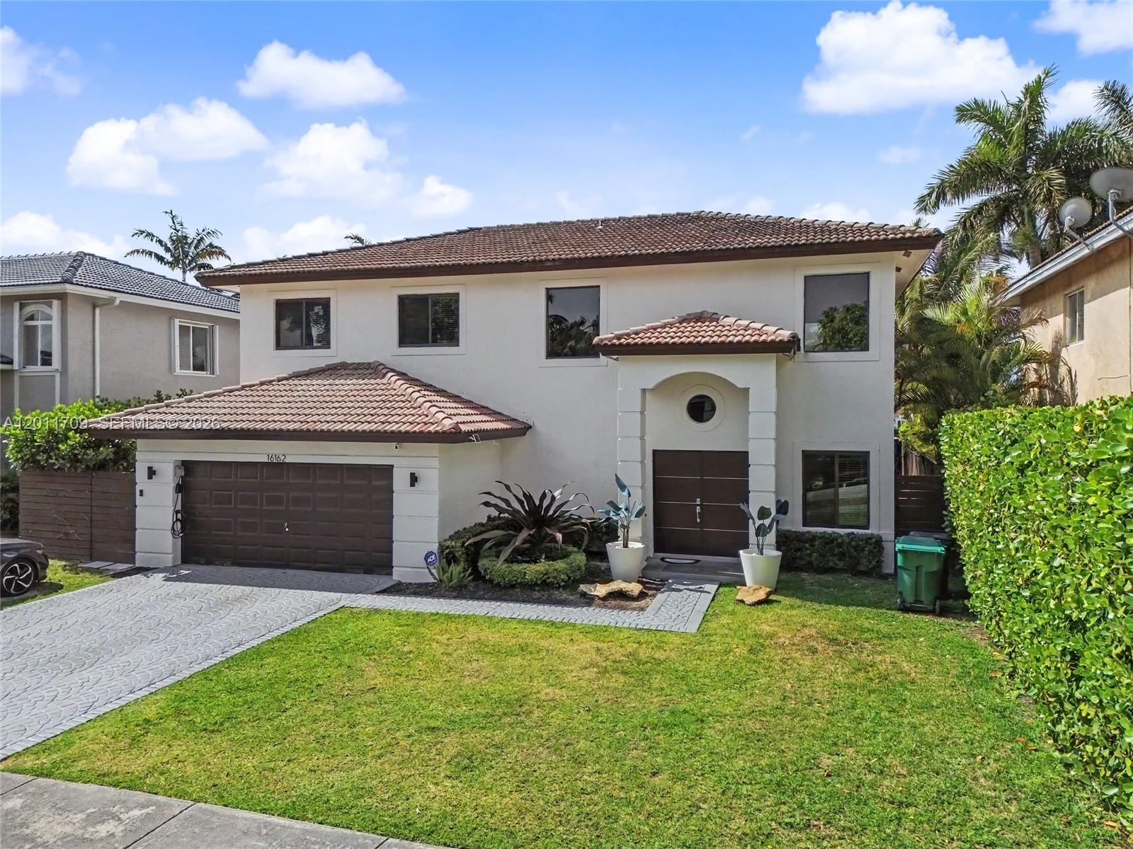 A two-story house with a brown tile roof, a garage, and a front lawn — 16162 SW 143rd St, Miami FL 33196, MIAMI, FL