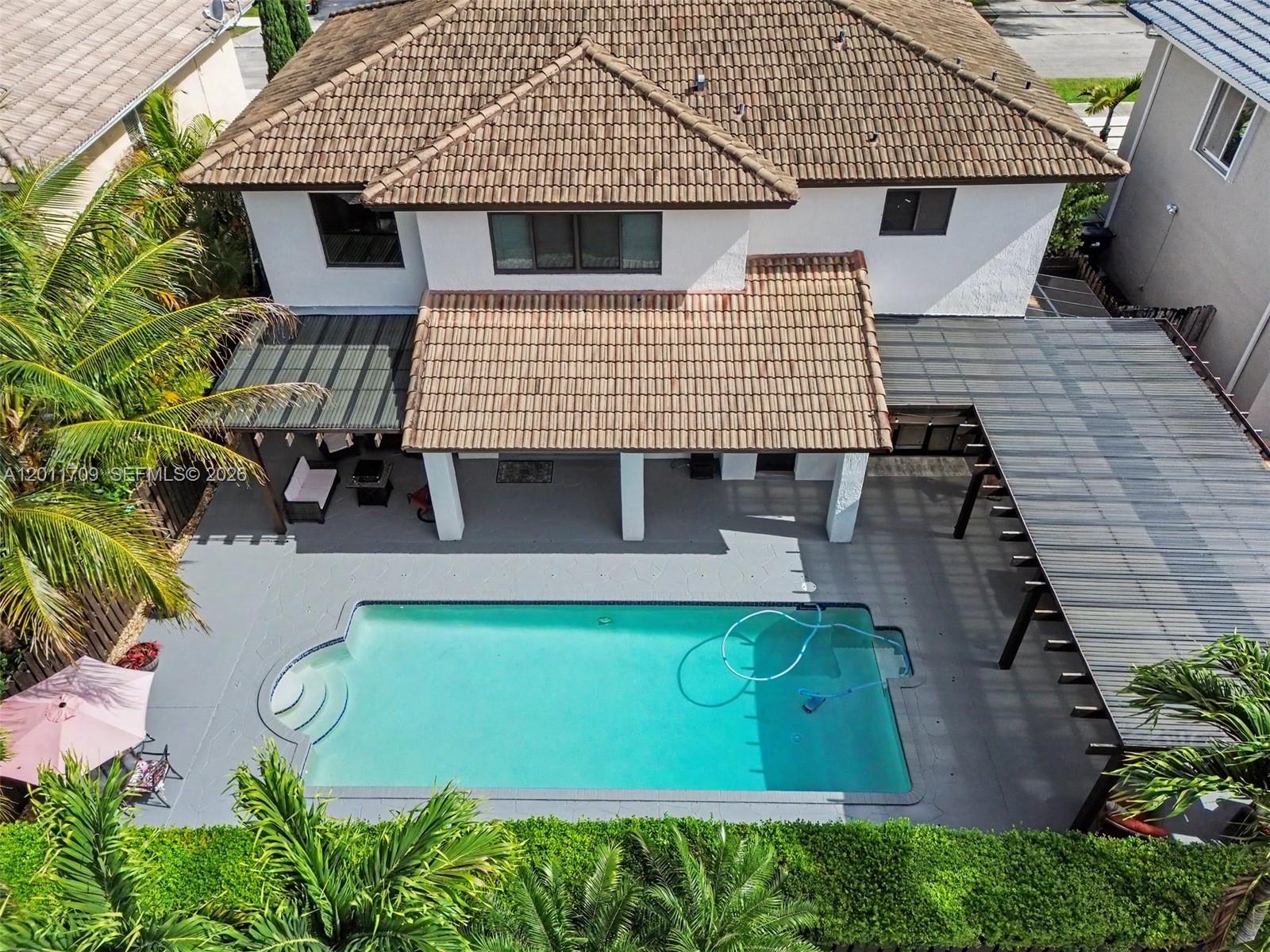An aerial view of a two-story house with a tiled roof, pool, and covered patio — 16162 SW 143rd St, Miami FL 33196, MIAMI, FL
