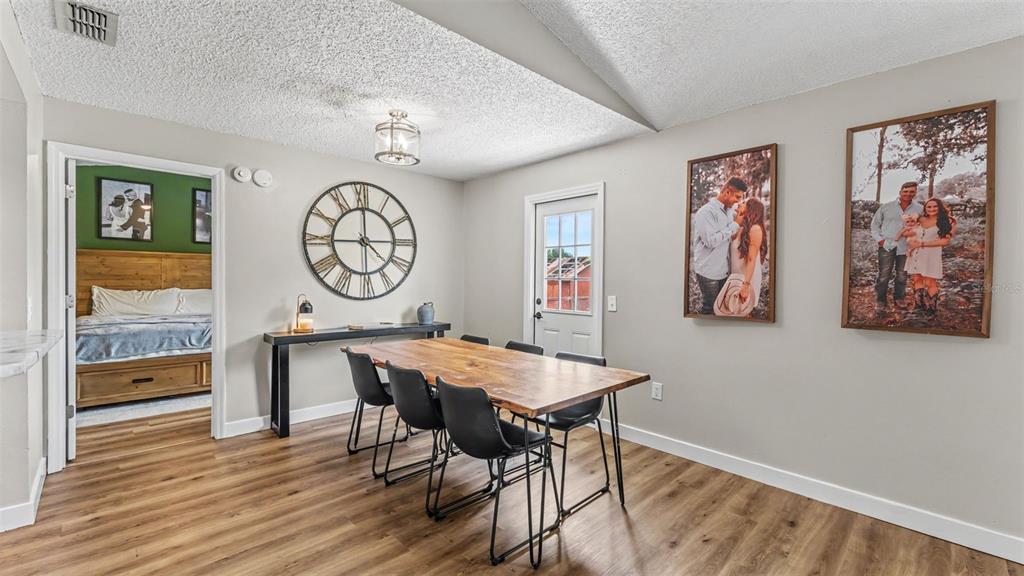 A dining room features a wooden table, black chairs, a large wall clock, and photos — 5303 KNIGHTS STATION ROAD, LAKELAND, FL