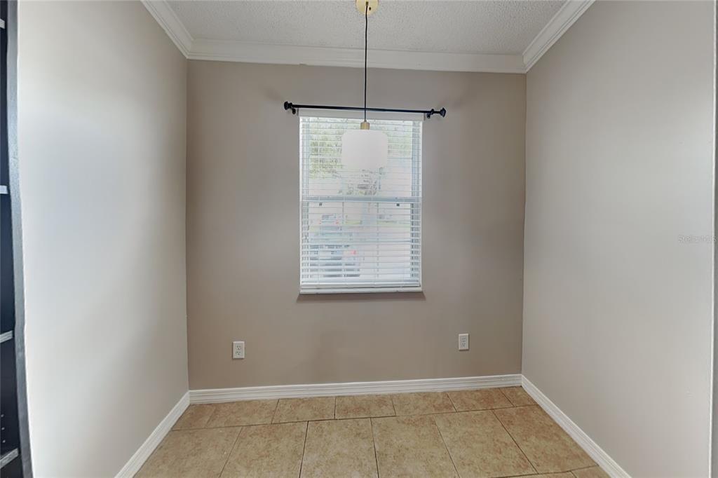 A small dining area features beige walls, tile flooring, a single window, and a pendant light — 111 HIDDEN ARBOR COURT, SANFORD, FL