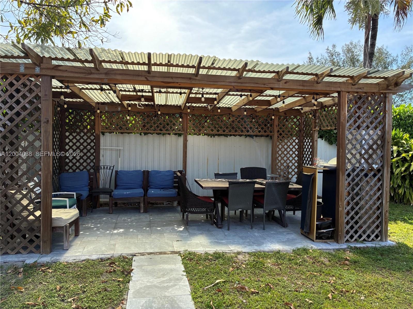 A living room features two floral sofas, a patterned coffee table, and a wall decal — 1440 NE 174th St, North Miami Beach FL 33162, NORTH MIAMI BEACH, FL
