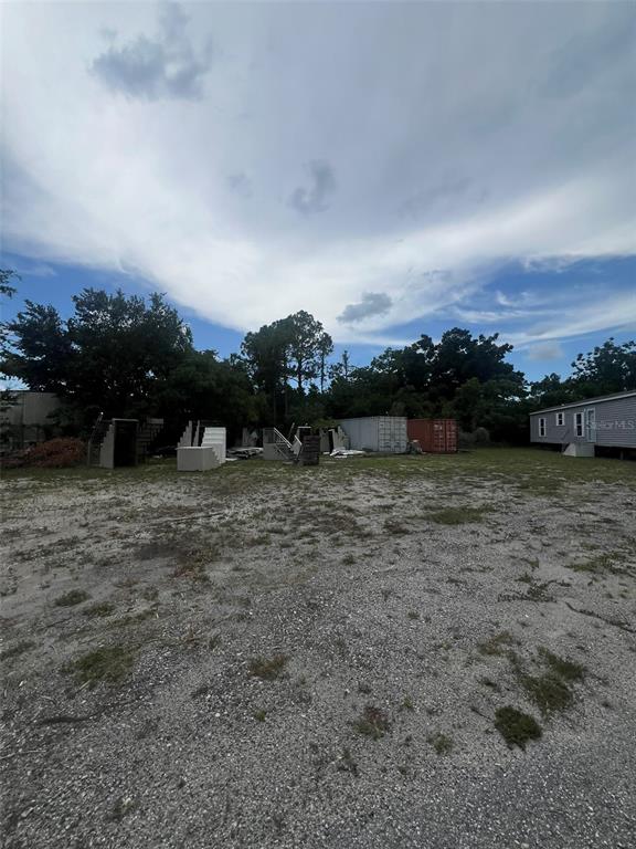 A gravel lot features several sets of stairs, two shipping containers, and a mobile home — 10916 N NEBRASKA AVENUE, TAMPA, FL