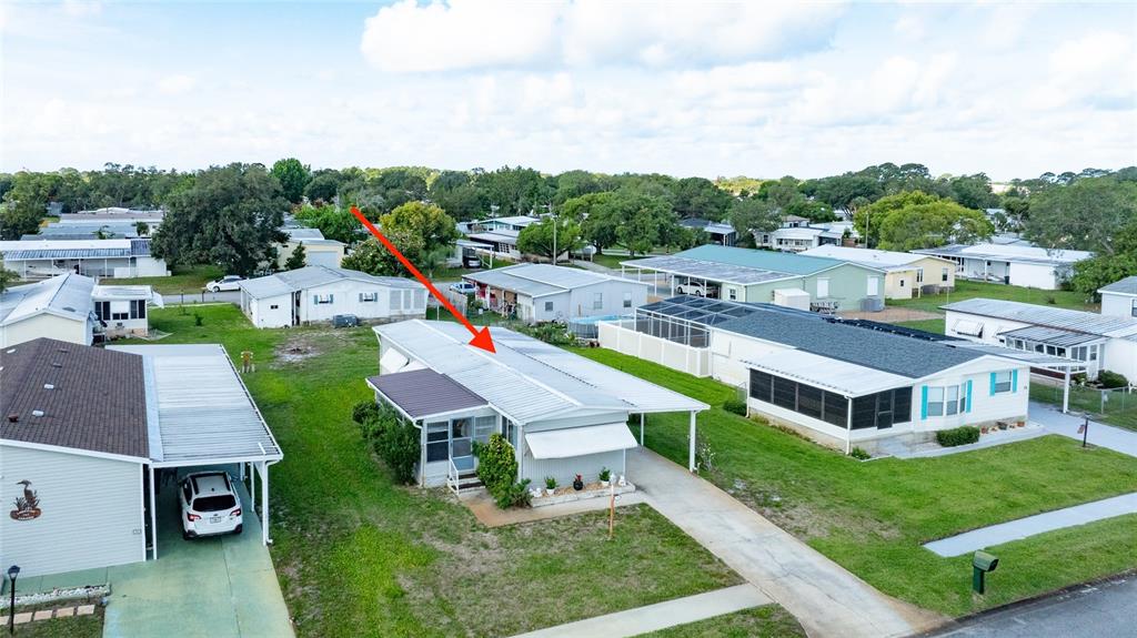 An aerial view shows a single-story mobile home with a metal roof and attached carport — 706 LEWARD WAY, PORT ORANGE, FL