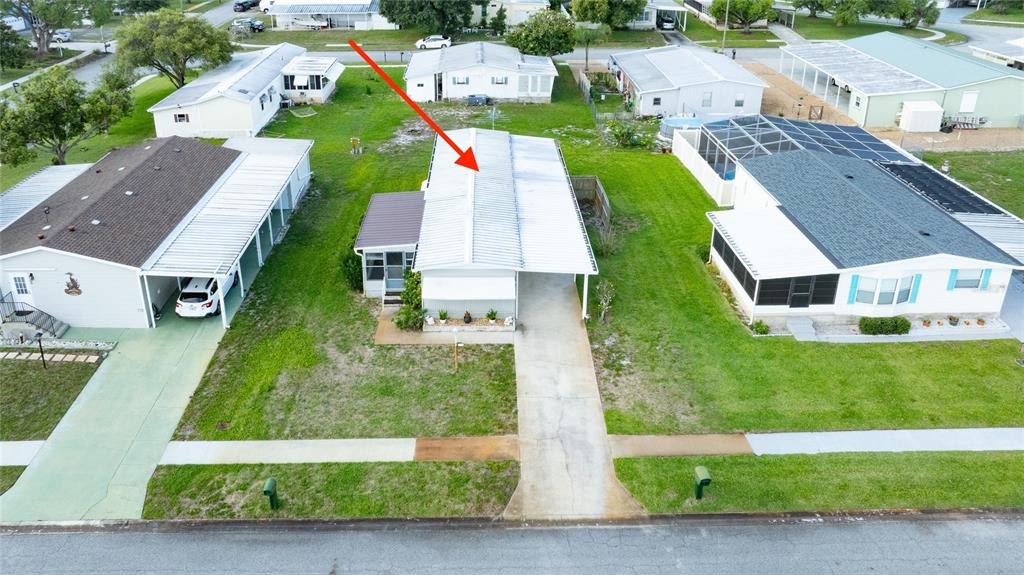 An aerial view shows a single-story mobile home with a white metal roof and carport — 706 LEWARD WAY, PORT ORANGE, FL