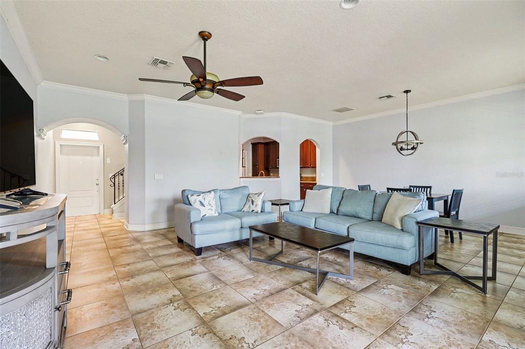 A living room features light blue sofas, a dark coffee table, and tiled flooring — 1380 ISABELLA DRIVE UNIT 105, MELBOURNE, FL