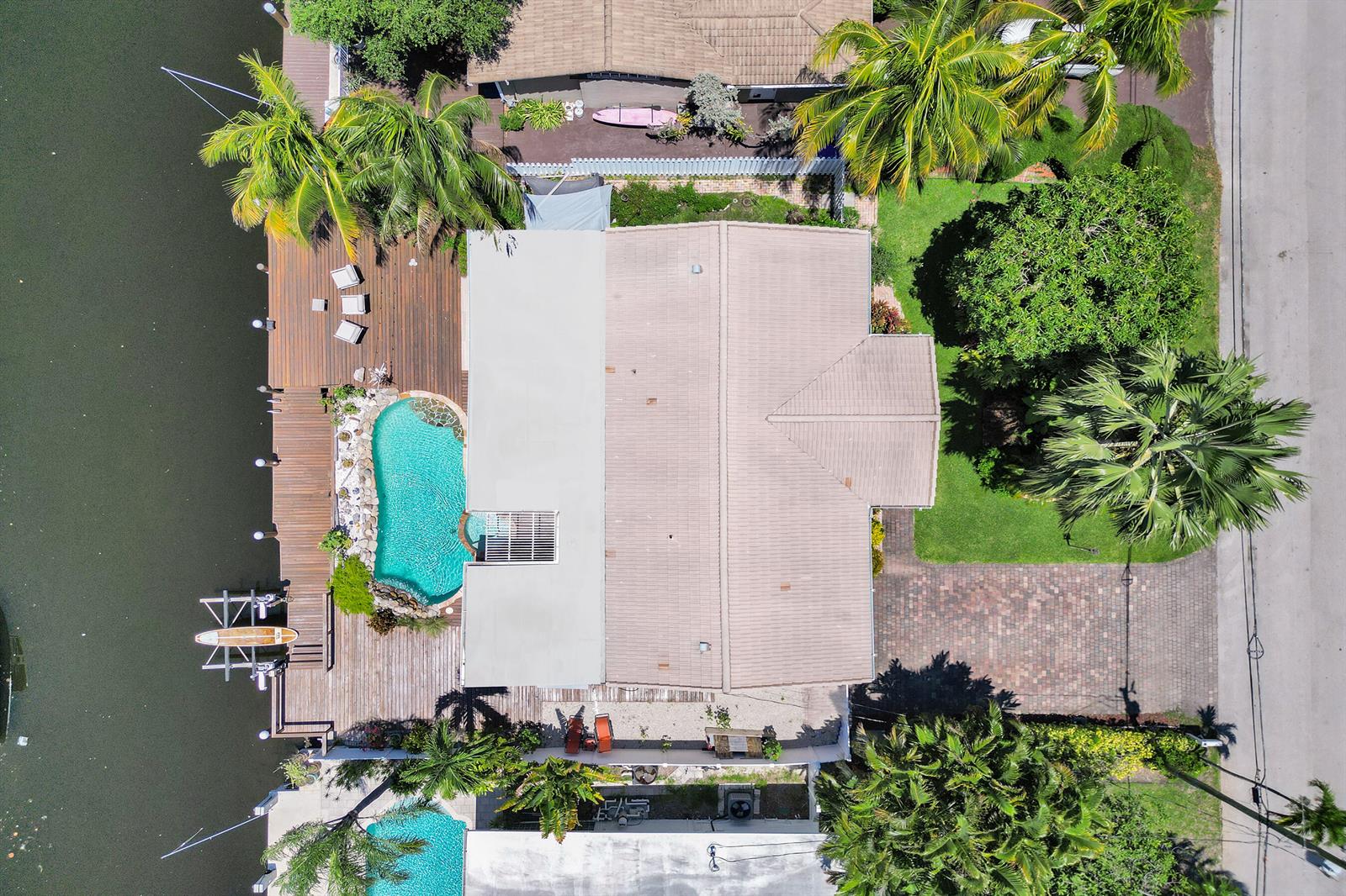 An aerial view of a waterfront house with a pool, wooden deck, and palm trees — 2265 SE 12th Street, Pompano Beach FL 33062, POMPANO BEACH, FL
