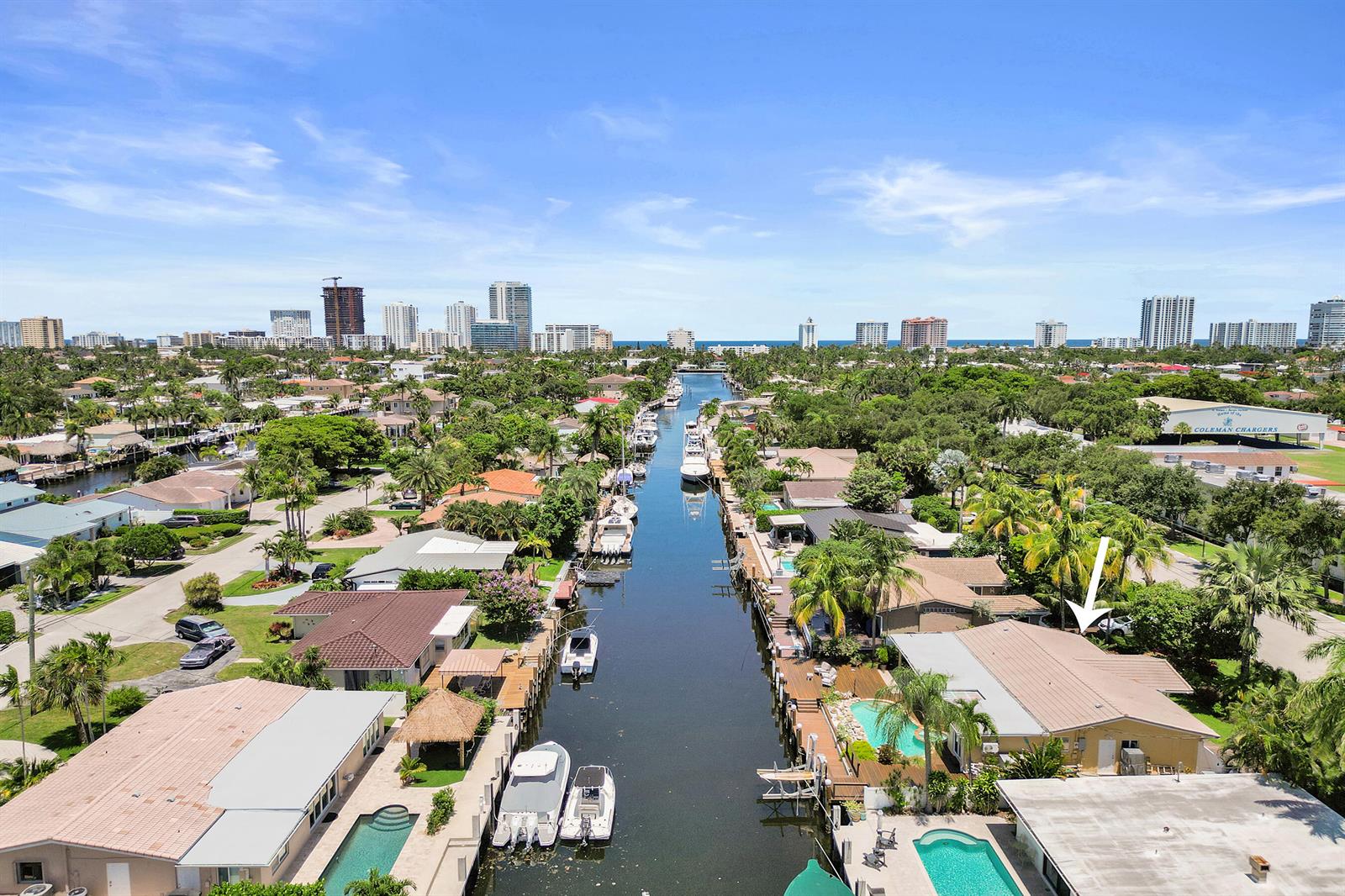 An aerial view of a canal-front residential neighborhood with houses, swimming pools, and docked boats — 2265 SE 12th Street, Pompano Beach FL 33062, POMPANO BEACH, FL