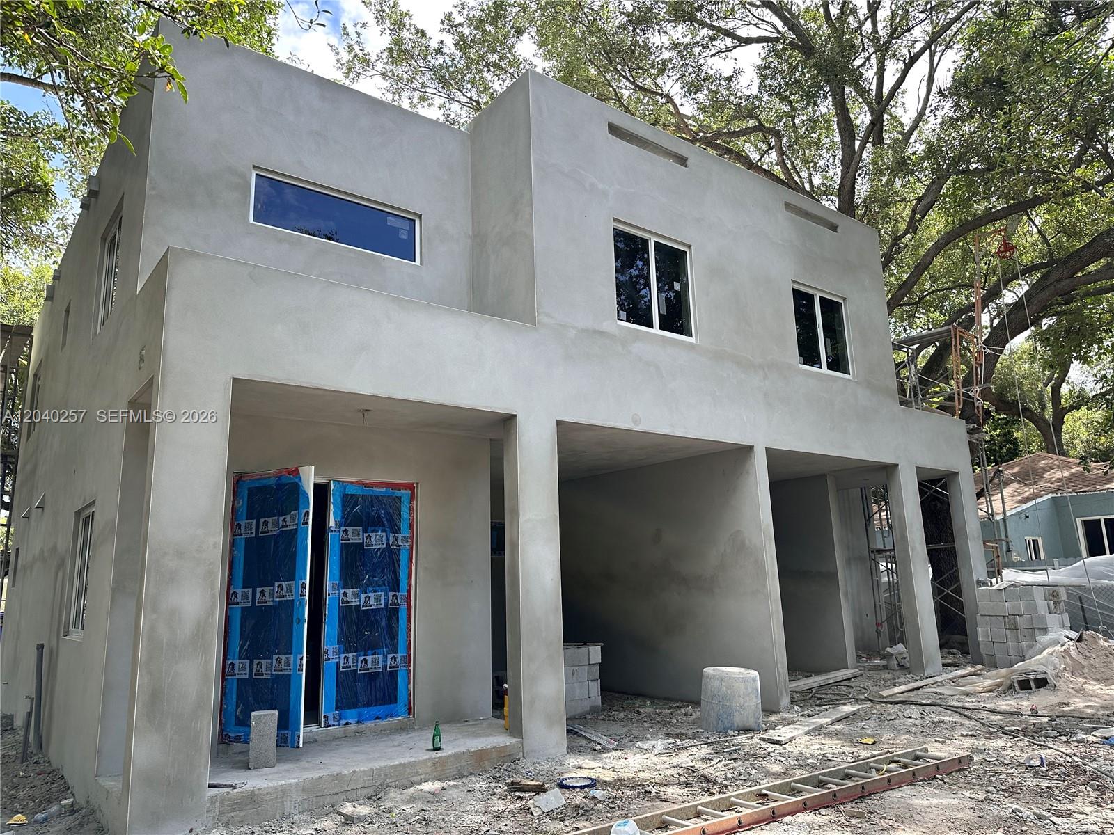 A two-story white modern house under construction with a covered patio and unfinished yard — 53 NE 60 ST # 0, Miami FL 33137, MIAMI, FL
