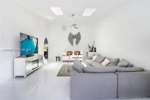 A bright living room features white walls, a large gray sectional, and a mirrored console — 270 SE 7th St, Dania Beach FL 33004, DANIA BEACH, FL
