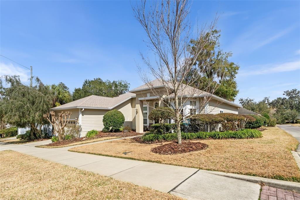 A single-story house with tan siding and a front yard sits under a blue sky — 3495 SW 73RD WAY, GAINESVILLE, FL