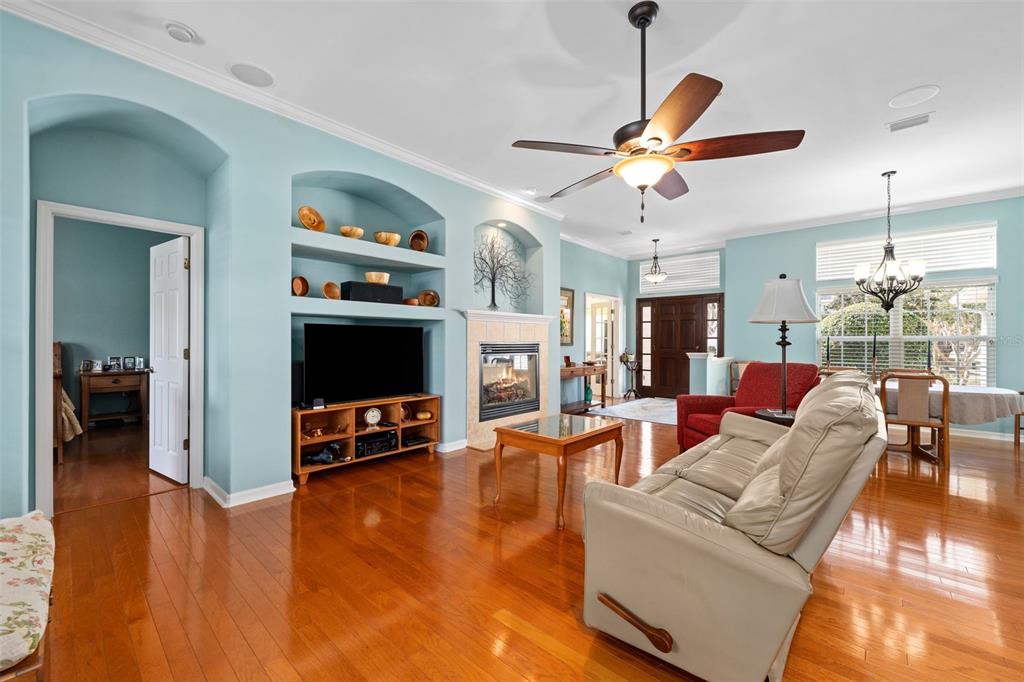 A living room features light blue walls, hardwood floors, a fireplace, and a ceiling fan — 3495 SW 73RD WAY, GAINESVILLE, FL