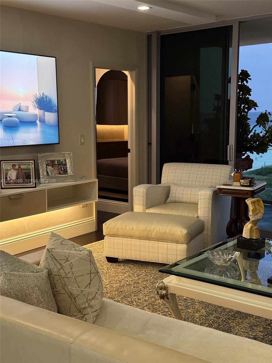 A living room features a plaid armchair with an ottoman, a glass-topped table, and ocean views — 1455 Ocean Dr # 904, Miami Beach FL 33139, MIAMI BEACH, FL