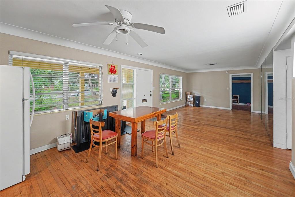 A dining area with hardwood floors, a ceiling fan, and a wooden table with chairs — 6415 2ND AVENUE N, ST PETERSBURG, FL