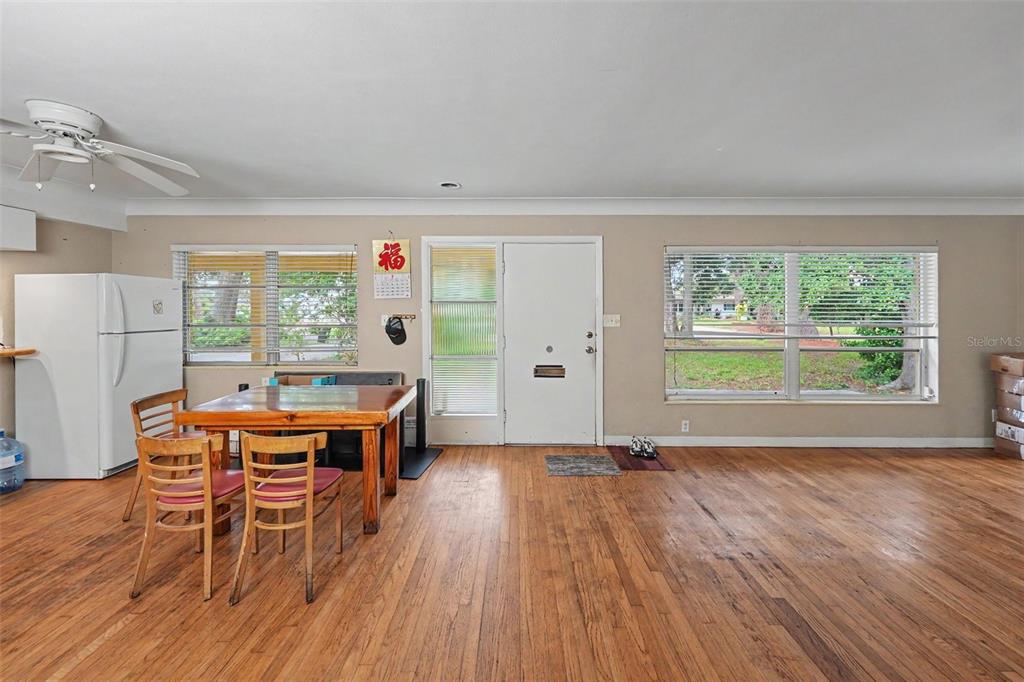 This room features hardwood floors, a dining table, a white refrigerator, and a front door — 6415 2ND AVENUE N, ST PETERSBURG, FL