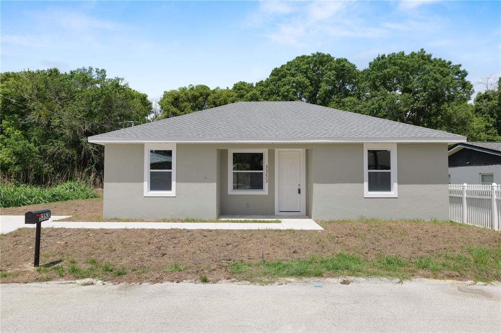 A single-story house with a gray exterior, white trim, and a gray shingled roof — 3353 S COMBEE ROAD, LAKELAND, FL