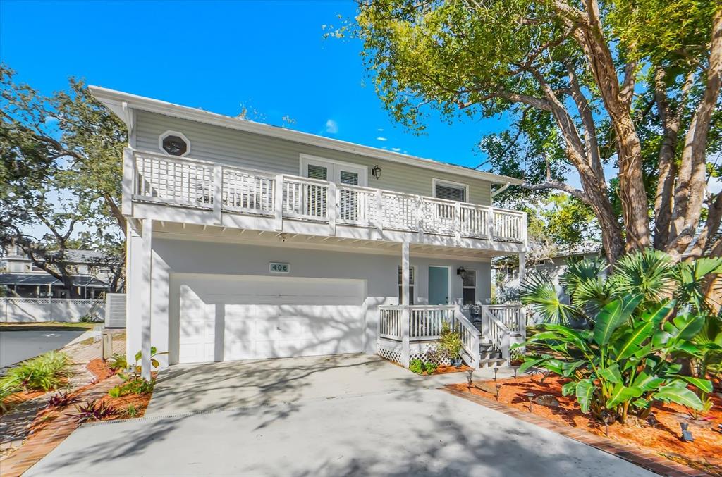 A two-story house with light gray siding, a white garage door, and a second-floor balcony — 408 GEORGIA AVENUE, CRYSTAL BEACH, FL