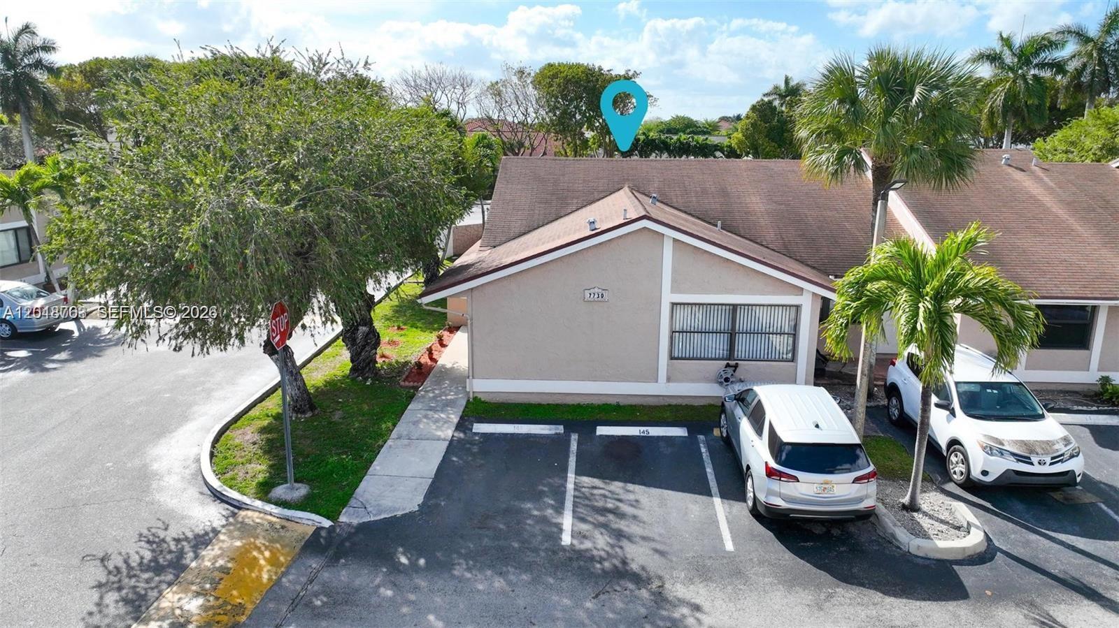 An exterior view of a single-story residential building with two parking spaces in front — 7730 SW 156th Ct # A145, Miami FL 33193, MIAMI, FL