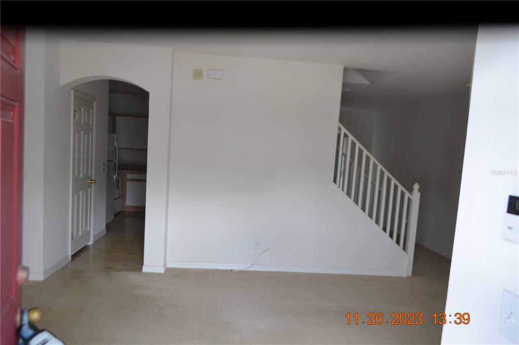 An interior view shows a carpeted living area with a staircase and an arched doorway — 3343 BROKEN BOW DRIVE, LAND O LAKES, FL