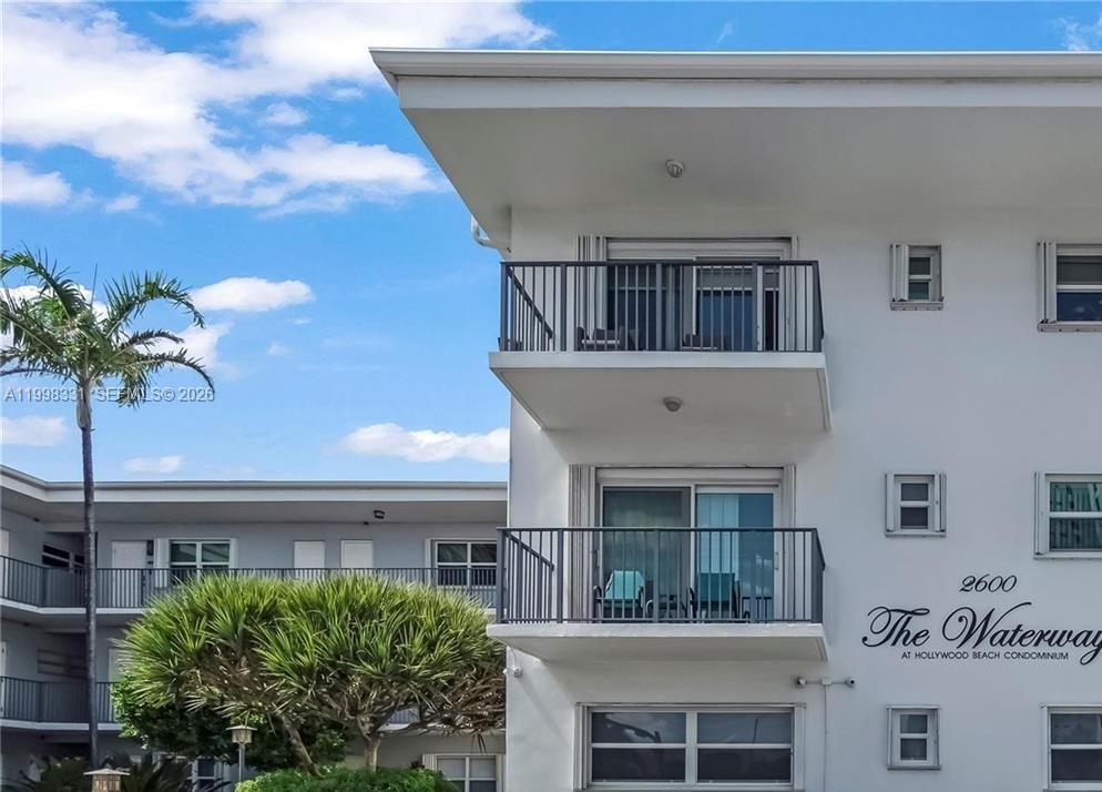The exterior of a white multi-story condominium building features balconies and a palm tree — 2600 S Ocean Dr # S201, Hollywood FL 33019, HOLLYWOOD, FL
