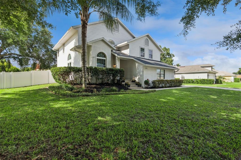 A two-story house with white siding and brick accents sits on a grassy lawn — 1458 ROYAL CIRCLE, APOPKA, FL