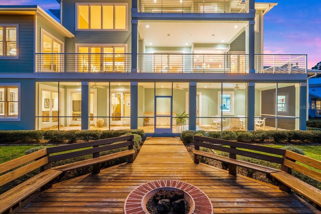 A multi-story house with a screened-in porch, wooden deck, and a circular fire pit — 2806 BAY VISTA COURT, NEW SMYRNA BEACH, FL
