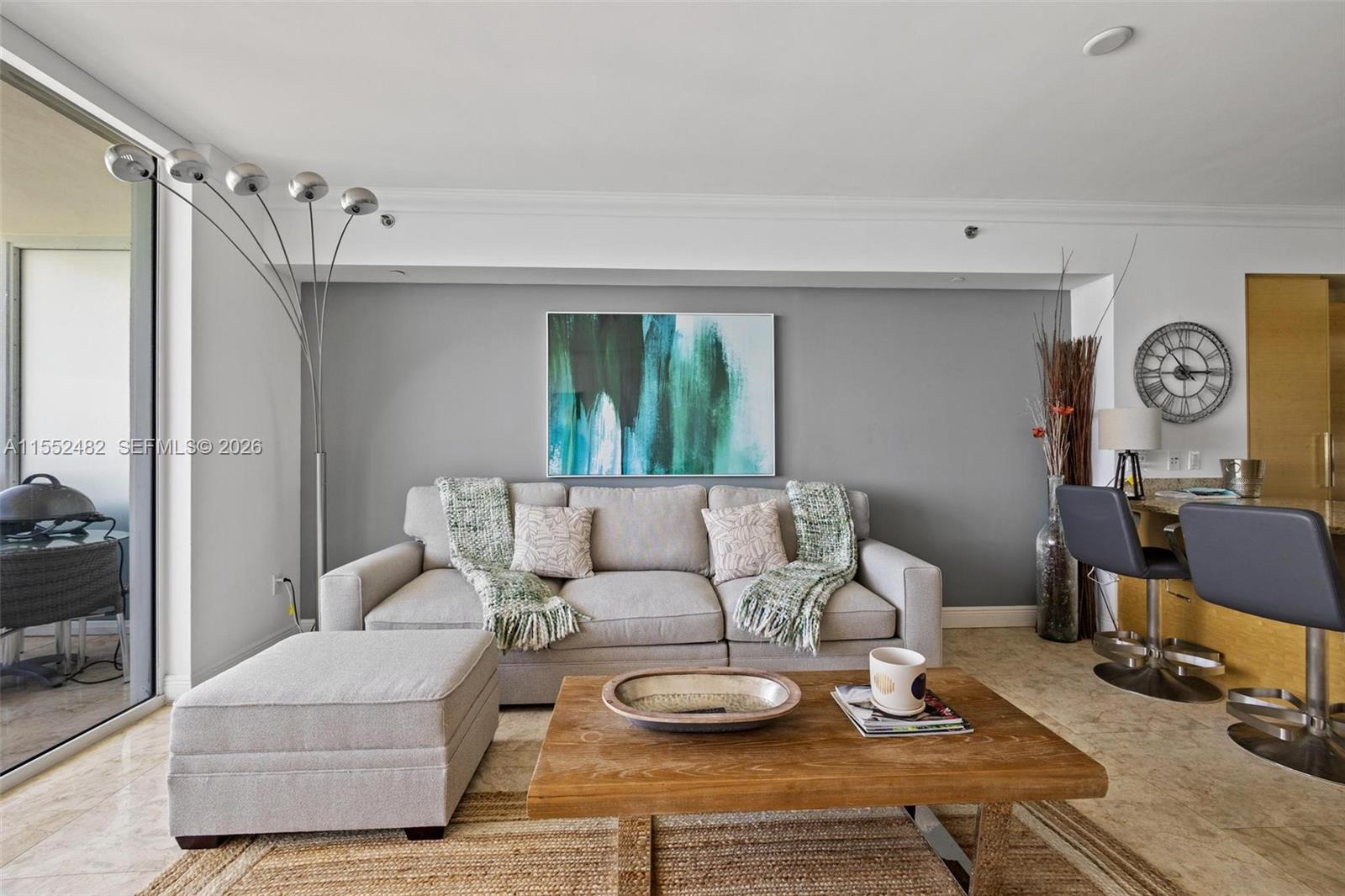 A living room features a grey sofa, a wooden coffee table, and an accent wall — 1830 S Ocean Dr # 5005, Hallandale Beach FL 33009, HALLANDALE BEACH, FL