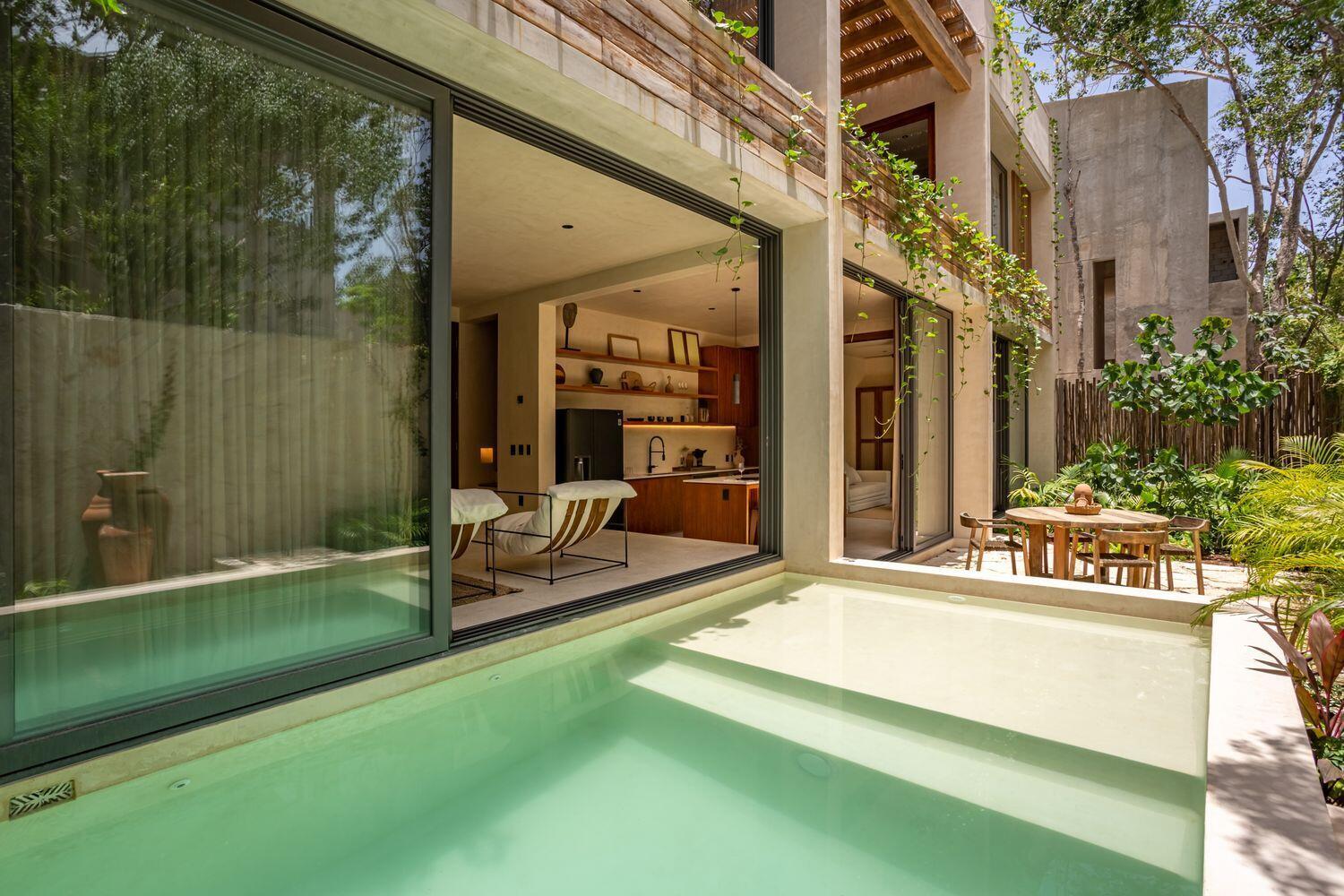 A modern home features a private pool, sliding glass doors, and an open-concept interior — Amari Tulum 10 Avenida Norte & Calle Palma, FL
