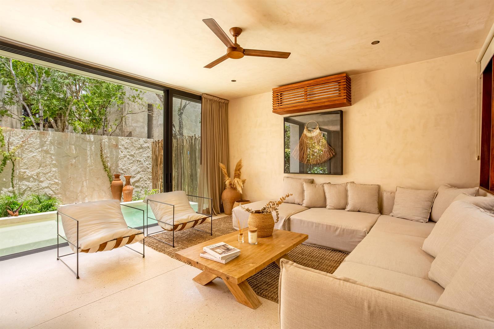 A living room with a sectional sofa, wooden coffee table, and sliding doors to a patio — Amari Tulum 10 Avenida Norte & Calle Palma, FL