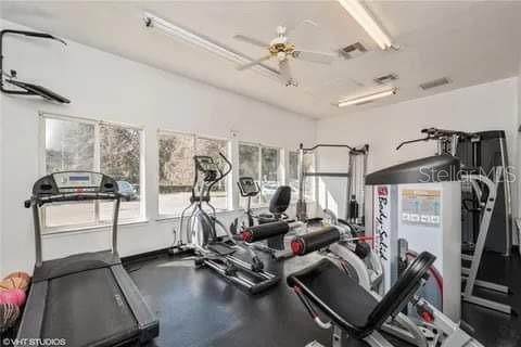 A home gym featuring a treadmill, elliptical machine, weight equipment, and a ceiling fan — 4000 SW 23RD STREET UNIT 4-103, #4, GAINESVILLE, FL