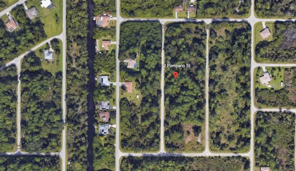 This aerial map view shows a wooded, undeveloped residential lot surrounded by neighboring houses — 72 POMPANO STREET, PORT CHARLOTTE, FL