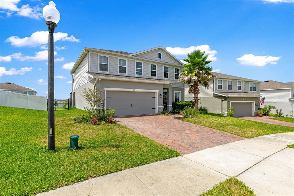 A two-story suburban house with a brick paver driveway and an attached two-car garage — 3133 HILL POINT STREET, MINNEOLA, FL