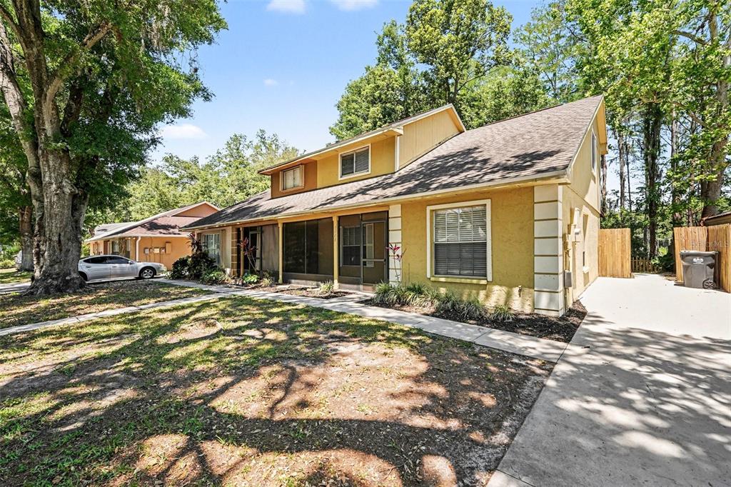 A two-story yellow house with a screened porch and a concrete driveway — 3408 LAUREL DALE DRIVE, TAMPA, FL