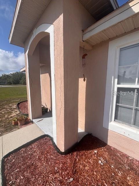 A stucco-covered porch column shows vertical cracks near the entrance of a house — 1716 MINNOW COURT, POINCIANA, FL